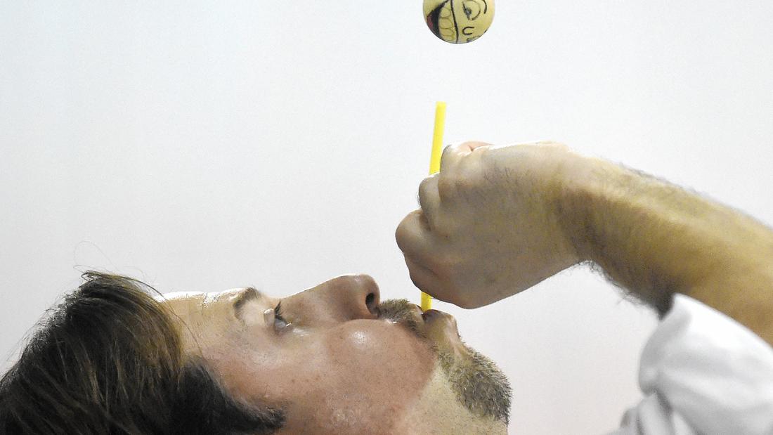 Eric 'Eric Energy' Krupkin blows through a straw to keep a ping pong ball aloft during his science presentation at Carroll Lutheran School in Westminster Wednesday, March 16, 2016.